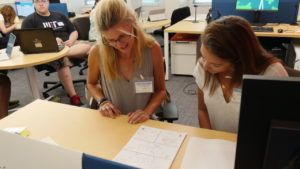 Two women looking at a piece of paper together